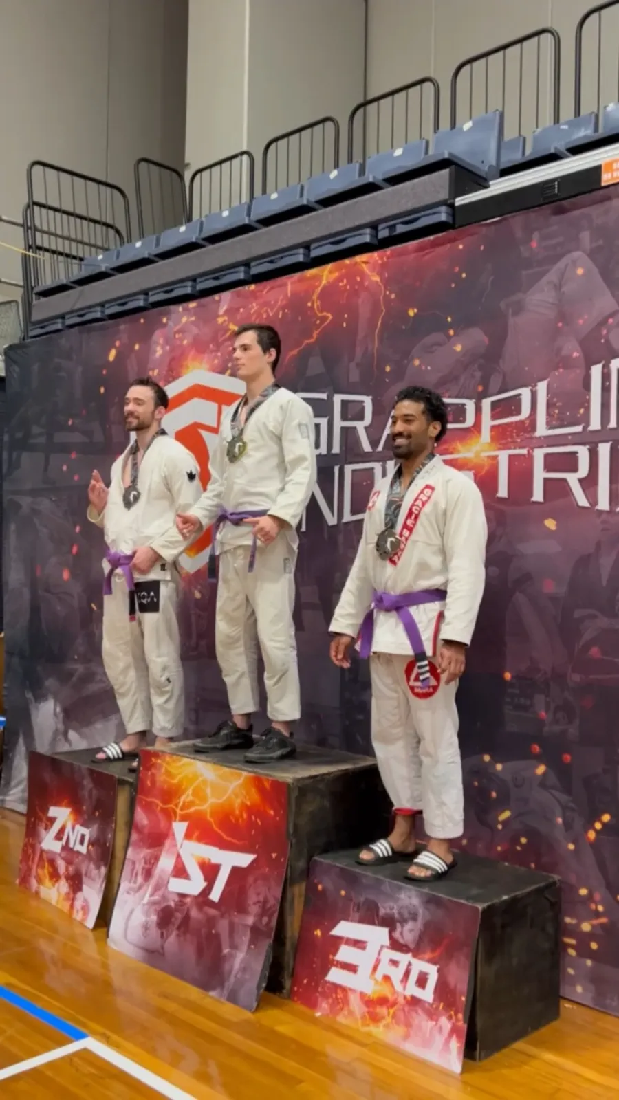 Imaad Karim on the podium in his gi and purple belt at a Grappling Industries Brazilian jiu-jitsu tournament